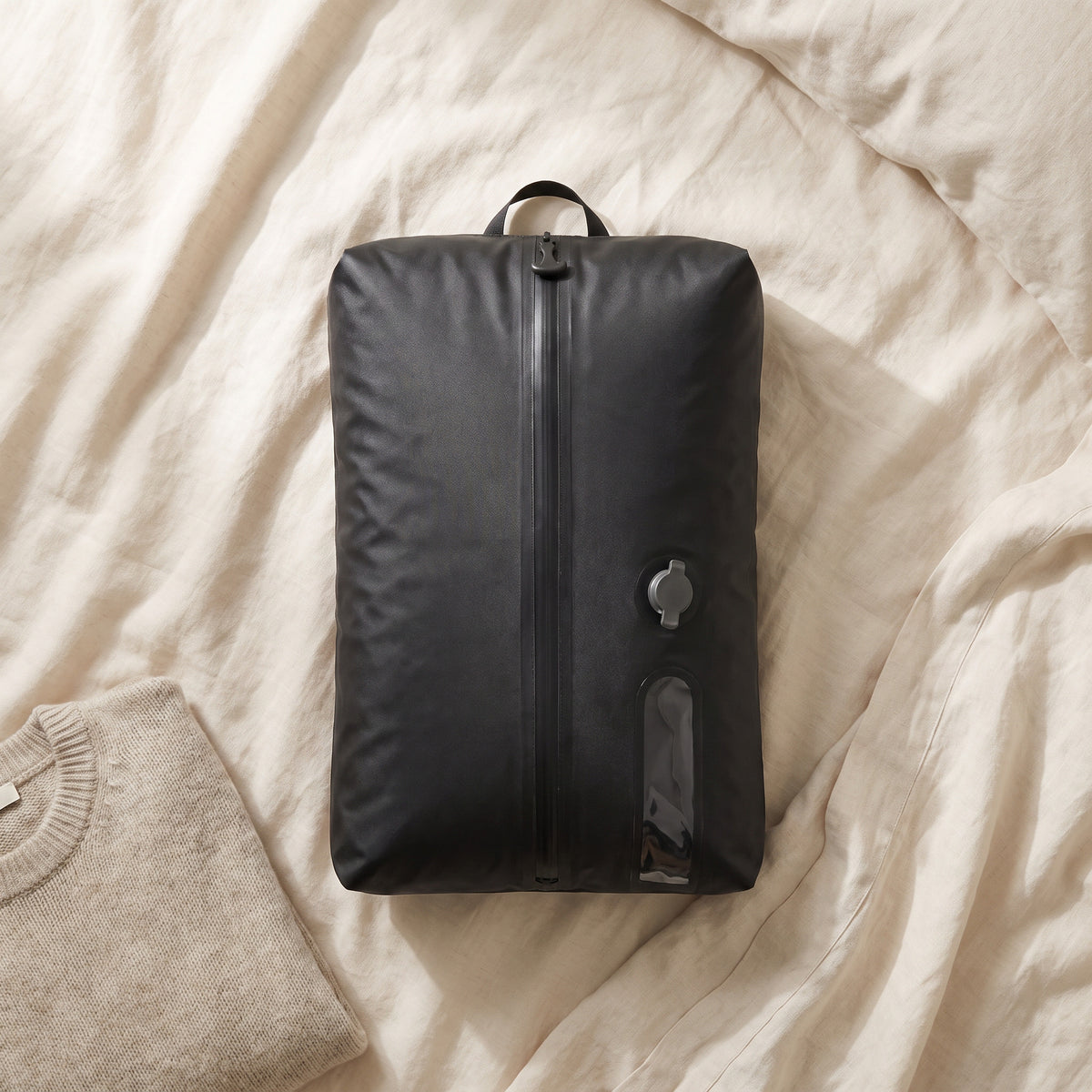 Kit S SUCTO lleno de ropa sobre una cama de lino