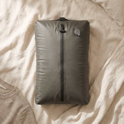 Kit L SUCTO lleno de ropa sobre una cama de lino
